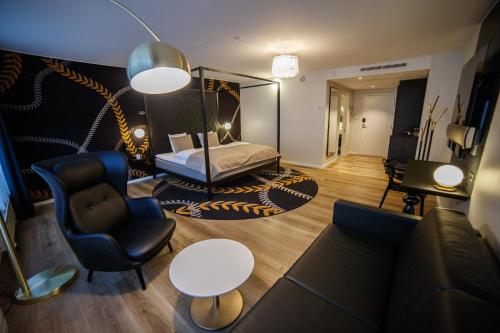 a living room with a bed and a chair at Best Western Plus Hotel Eyde in Herning