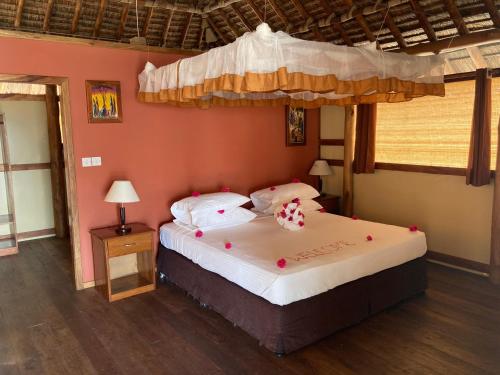 ein Schlafzimmer mit einem großen Bett mit Baldachin in der Unterkunft Barry's Beach Resort in Mkwaja