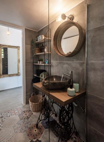 a bathroom with a sink and a mirror on the wall at Maison Triantatria in Plaka Milou