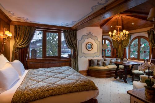 a bedroom with a bed and a couch and a table at Airelles Courchevel, Les Airelles in Courchevel
