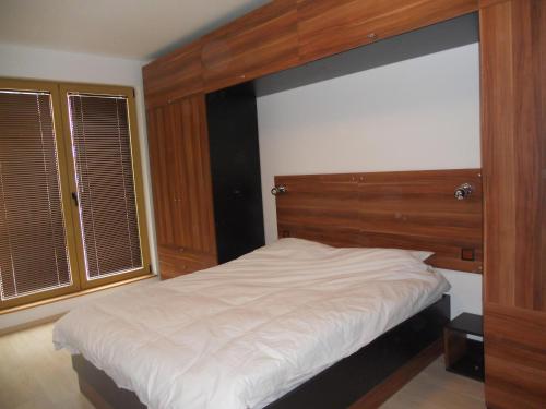 バンスコにあるRoy's Apartment in St John Parkのベッドルーム(白い大型ベッド1台、木製ヘッドボード付)