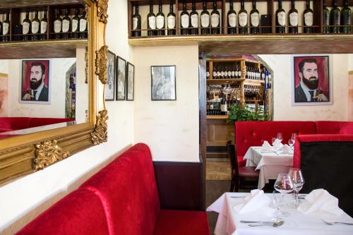 a restaurant with red chairs and tables with wine bottles at Hotel Stadt Berlin in Jessen