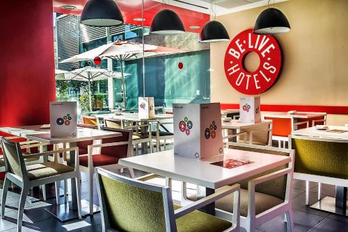 un restaurante con mesas y sillas y un cartel de dona en Be Live City Center Talavera, en Talavera de la Reina