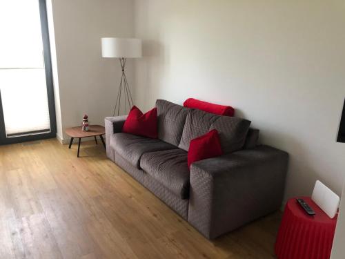 a living room with a gray couch with red pillows at Tor zum Meer in Helgoland