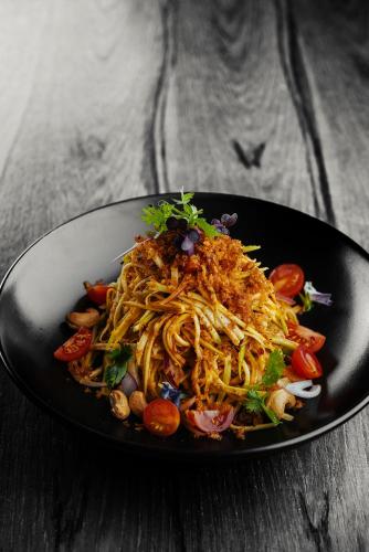 a plate of food with pasta and vegetables on a table at Dusit Thani Dubai in Dubai