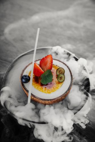 a dessert with fruit and whipped cream on a glass plate at Dusit Thani Dubai in Dubai