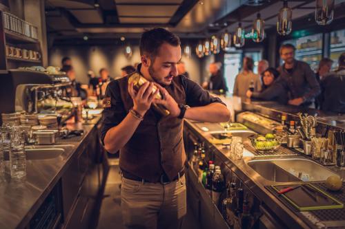 a man standing behind a bar in a restaurant at Revier Mountain Lodge Adelboden in Adelboden
