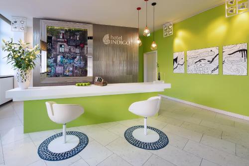 2 Stühle in einem Salon mit grünen Wänden in der Unterkunft Hotel Indigo Berlin – Ku’damm, an IHG Hotel in Berlin