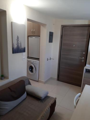 a living room with a door and a washer and dryer at Kosmos Service Apartment Modern Spirit City Center With Additional Cost Parking in Thessaloniki