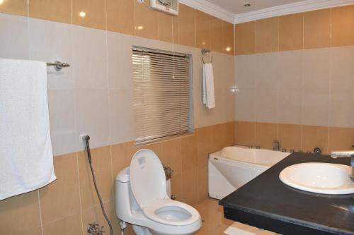 a bathroom with a toilet and a sink at Safari Club 2 Bahria Town in Rawalpindi