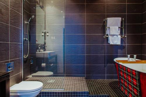 a bathroom with a shower and a toilet and a sink at Malmaison Edinburgh in Edinburgh