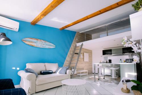 a living room with a couch and a surfboard on the wall at 2 pièces avec grande terrasse - Centre de Toulon in Toulon