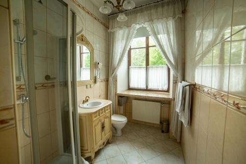 łazienka z umywalką, toaletą i oknem w obiekcie Zamek Dubiecko w mieście Dubiecko
