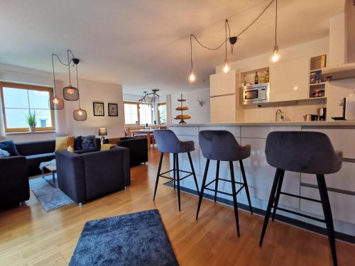 a kitchen and living room with a bar and chairs at Chalet Marille Gastein in Bad Gastein