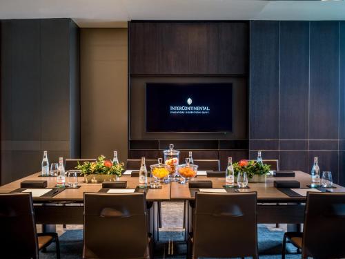 a conference room with tables and chairs and a flat screen tv at InterContinental Singapore Robertson Quay by IHG in Singapore