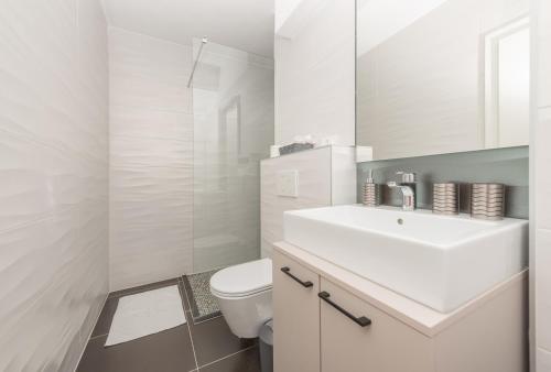 een witte badkamer met een wastafel en een toilet bij Apartment Villa Barisimo in Makarska