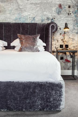 a bedroom with a large bed with a gray headboard at Malmaison Edinburgh in Edinburgh