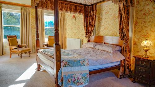 a bedroom with a canopy bed and a chair at Banoge House in Donaghcloney