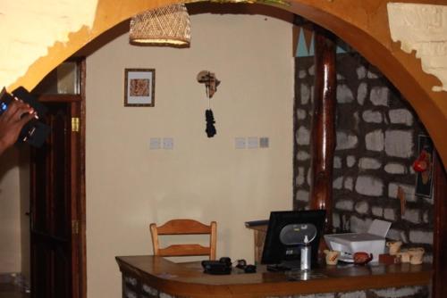 a person taking a picture of a room with a desk at Kyaninga Royal Cottage in Fort Portal