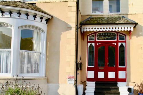 a red door on the side of a building at Mostyn Villa 2 Free Private Parking in Llandudno
