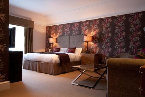 um quarto de hotel com uma cama e um sofá em The Townhouse Hotel em Melrose