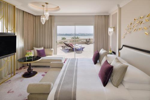 a hotel room with a large bed and a living room at Mövenpick Hotel Bahrain in Manama