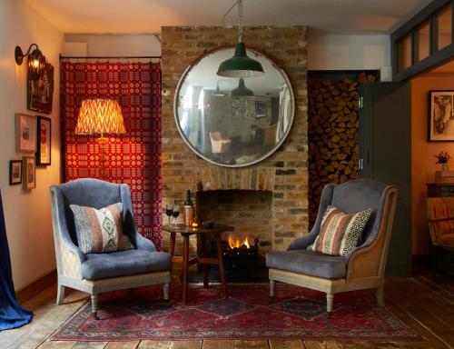 a living room with two chairs and a fireplace at Artist Residence London in London