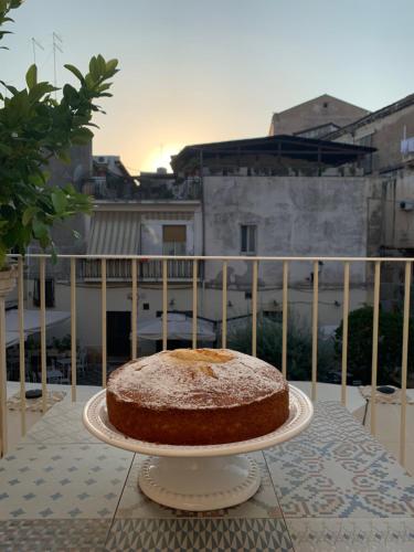 a cake sitting on a plate on a balcony at La Residenza del Reginale in Siracusa