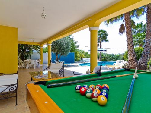 a pool table on a patio with palm trees at Villa Villa Monte da Torre by Interhome in Alfarrobeira