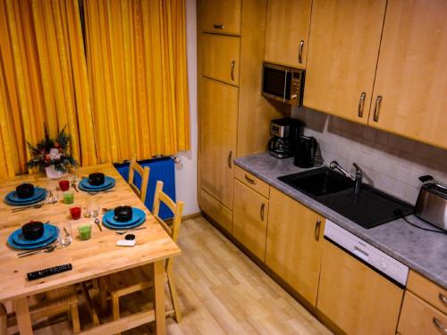 une cuisine avec une table en bois et un évier dans l'établissement Apartment Dachsteingasse by Interhome, à Schladming