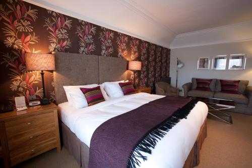 a bedroom with a large bed and a living room at The Townhouse Hotel in Melrose