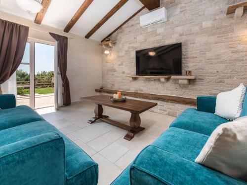 een woonkamer met twee blauwe banken en een tv bij Villa Lucija by Interhome in Pazin