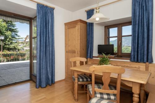 ein Esszimmer mit einem Tisch, Stühlen und einem TV in der Unterkunft Appartements Eppanerhof in Appiano sulla Strada del Vino