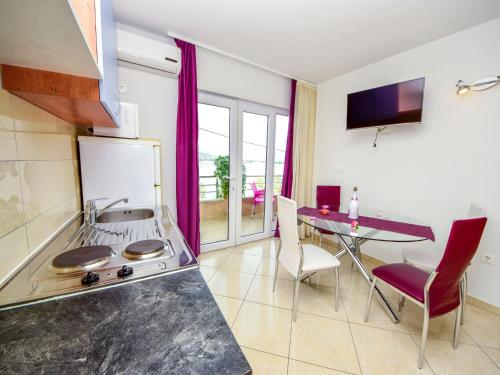 een keuken met een fornuis en een tafel met stoelen bij Apartment Vinka-2 by Interhome in Trogir