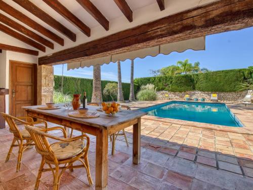 um pátio com uma mesa e cadeiras e uma piscina em Villa Finca Labranza by Interhome em Xàbia
