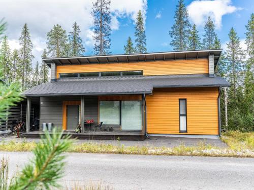 a house with an orange and black facade at Holiday Home Loma-saaga 3 by Interhome in Syöte