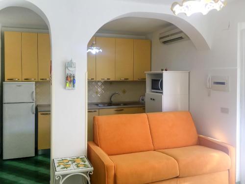 salon z pomarańczową kanapą w kuchni w obiekcie Apartment Casale di Torca by Interhome w mieście Torca