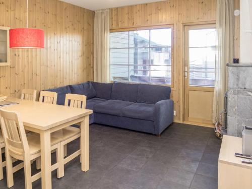 ein Wohnzimmer mit einem blauen Sofa und einem Tisch in der Unterkunft Holiday Home Rukatonttu d 12 by Interhome in Ruka