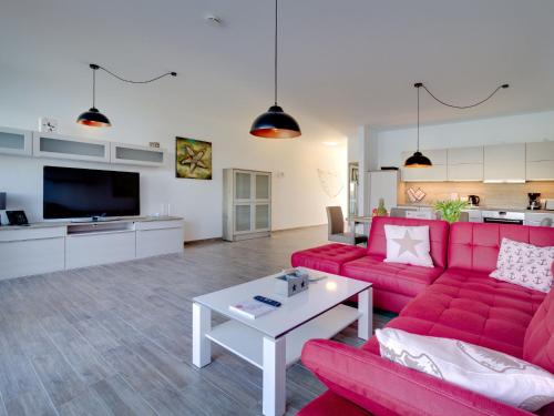 a living room with a red couch and a white table at Apartment Kapitänskajüte by Interhome in Großpösna