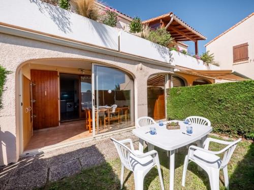d'une terrasse avec une table et des chaises blanches. dans l'établissement Apartment Les Soleils Rouges-14 by Interhome, à Vaux-sur-Mer