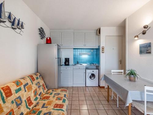 een woonkamer met een bank en een keuken bij Apartment Les Soleils Rouges-14 by Interhome in Vaux-sur-Mer