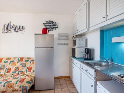 une petite cuisine avec un réfrigérateur et un évier dans l'établissement Apartment Les Soleils Rouges-14 by Interhome, à Vaux-sur-Mer