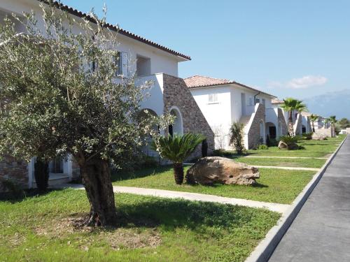 a pig laying in the grass in front of a house at Apartment A Suara Linda-1 by Interhome in Ghisonaccia