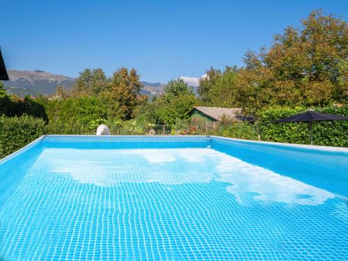a blue swimming pool with a view of the mountains at Apartment Rita by Interhome in Dražice