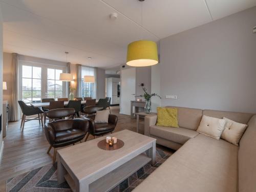 uma sala de estar com um sofá e uma mesa em Holiday Home Ganuenta-1 by Interhome em Colijnsplaat