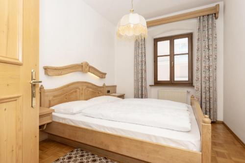 a bedroom with a large white bed with a chandelier at Appartements Eppanerhof in Appiano sulla Strada del Vino