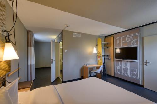 a hotel room with a bed and a sink at ibis Zürich City West in Zürich