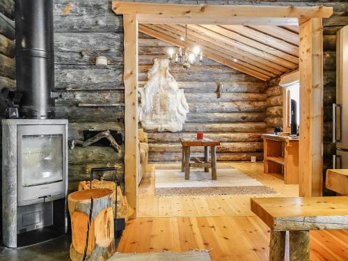 uma cabana de madeira com um fogão a lenha num quarto em Holiday Home Kelokota by Interhome em Salla