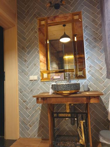 een badkamer met een wastafel en een spiegel bij Domek Nad Doliną in Orawka