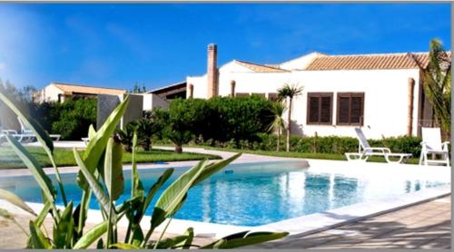 a swimming pool in front of a house at Borgo Pida in Trapani